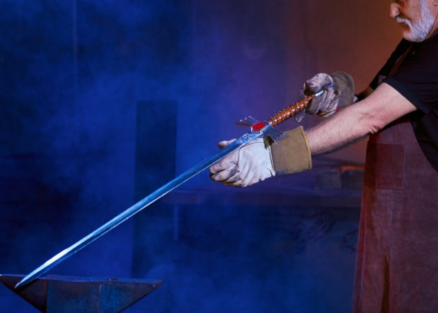 Master smith inspecting a custom handcrafted medieval sword on an anvil in a traditional forge.